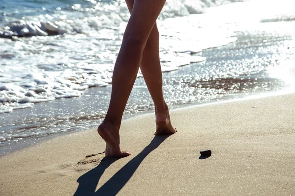 Eine junge Frau geht an einem Sommermorgen am Meer spazieren. Nahaufnahme Foto von Beinen — Stockfoto