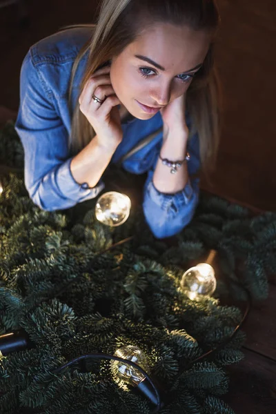 Çiçekçi ve ellerinin üzerinde Noel çelenk hazırlamak için dalları başlatmak bir köknar