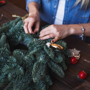 Dekoratör Noel çelenk çam dalları ve oyuncaklar ile hazırlar