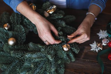 Dekoratör Noel çelenk çam dalları ve oyuncaklar ile hazırlar