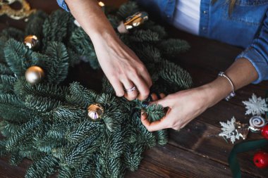 Dekoratör Noel çelenk çam dalları ve oyuncaklar ile hazırlar