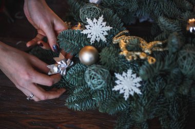 Dekoratör Noel çelenk çam dalları ve oyuncaklar ile hazırlar