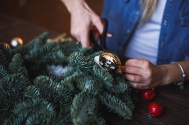 Dekoratör Noel çelenk çam dalları ve oyuncaklar ile hazırlar