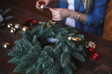 Dekoratör Noel çelenk çam dalları ve oyuncaklar ile hazırlar