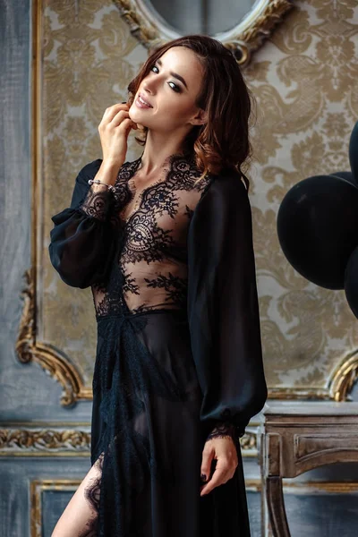 性感的年轻女子在一个黑色的闺房礼服在古典内饰 — 图库照片