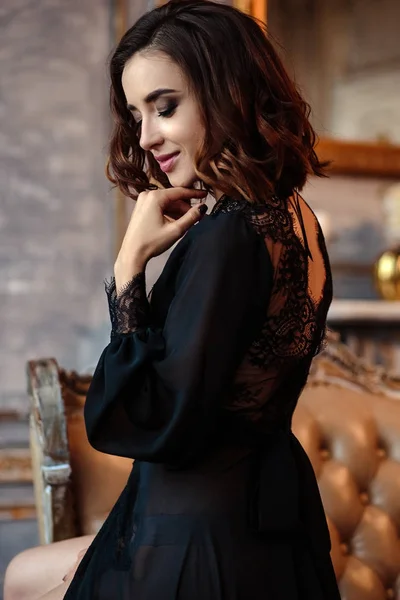 性感的年轻女子在一个黑色的闺房礼服在古典内饰 — 图库照片