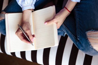 Ahşap bir masa üstünde Zamanlayıcı defter yakın çekim fotoğraf. El kağıt üzerine yazar. Düz yatıyordu kompozisyon.