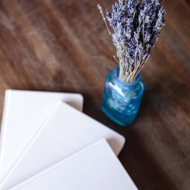 Close-up photo of light pink scheduler notebook on a wooden table with lavender. Flat lay composition.