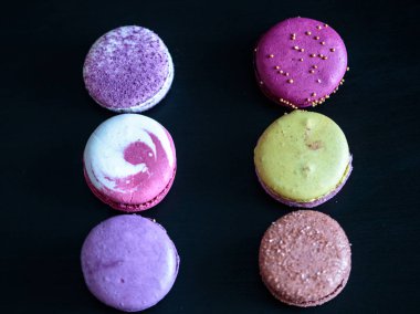 siyah ahşap bir masa üzerinde macaroons bileşimi. Makro fotoğraf renkli bisküvi kadar kapatın