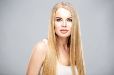 Parlak uzun düz saçları ve doğal makyajı olan güzel sarışın kadın. Moda portresi izole.