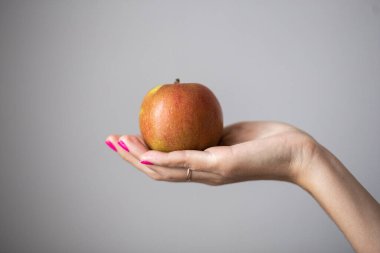Mükemmel pembe manikürlü kadın elleri bir elma tutar, konsept fotoğraf.