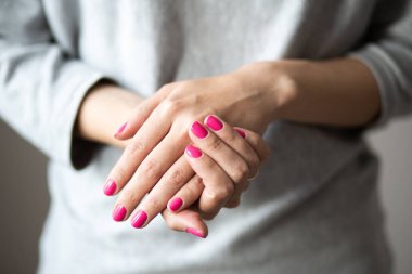 Manikür fotoğrafı, mükemmel pembe cilalı kadın elleri.