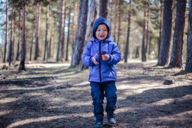 Küçük çocuk bahar ormanında yalnız.