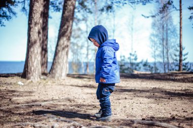 Küçük çocuk bahar ormanında yalnız.