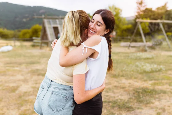 Vue arrière de copines qui se serrent dans leurs bras à la campagne. Meilleur ami, concept d'amour et d'amitié . — Photo