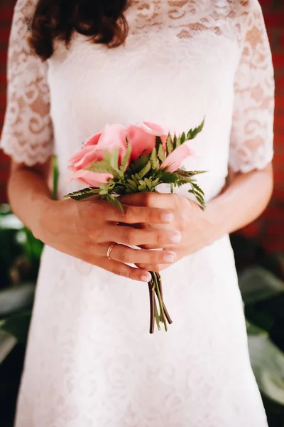 เจ้าสาวถือช่อดอกกุหลาบสีชมพูเล็ก ๆ ของเธอ คอนเซปต์วันแต่งงาน . — ภาพถ่ายสต็อก