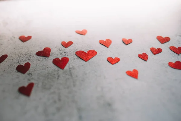 กระดาษแข็งรูปหัวใจแววสีแดงบนพื้นหลังซีเมนต์ ความรักและวันวาเลนไทน์ . — ภาพถ่ายสต็อก