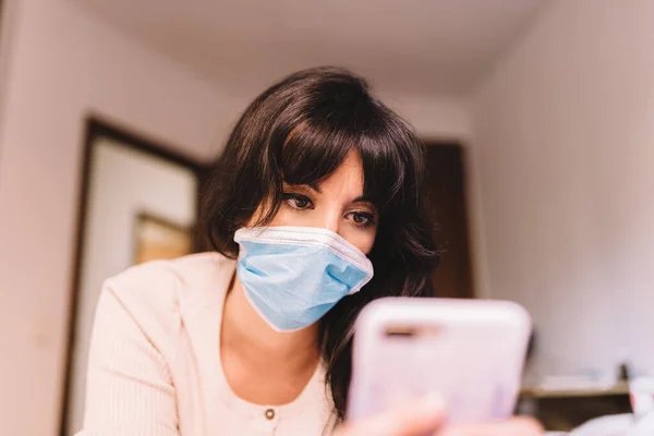 Kvinne Hjemme Åndedrettsmaske Med Mobiltelefon Kinesisk Pandemisk Coronavirus Virus Kovid stockfoto