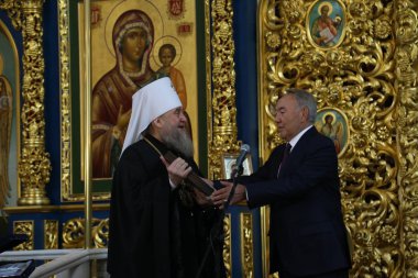 Nursultan Nazarbayev and Metropolitan Alexander speaking to people in Holy Assumption Cathedral on 7 January 2019 in Astana, Kazakhstan clipart