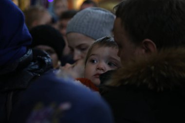 Baba ve çocuk 7 Ocak 2019 'da Astana, Kazakistan' daki Kutsal Varsayım Katedrali 'ne geliyor.