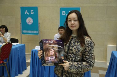 9 Haziran 2019 'da Astana, Kazakistan' da cumhurbaşkanlığı seçimlerinde saç kurutma makinesiyle kutu tutan genç kadınlar