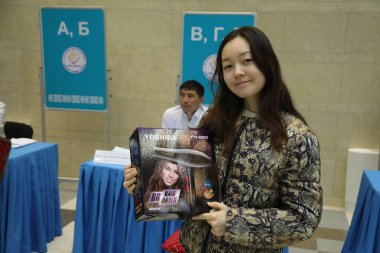 9 Haziran 2019 'da Astana, Kazakistan' da cumhurbaşkanlığı seçimlerinde saç kurutma makinesiyle kutu tutan genç kadınlar