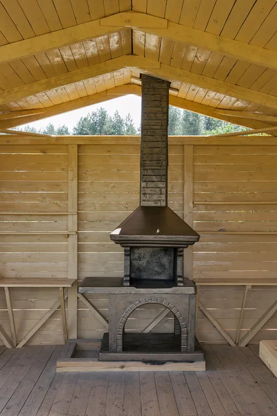 Newly built stone grill in a wooden pavilion — Stock Photo, Image