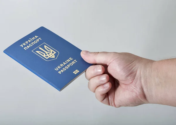 Mão segurando passaporte biométrico ucraniano contra fundo branco — Fotografia de Stock