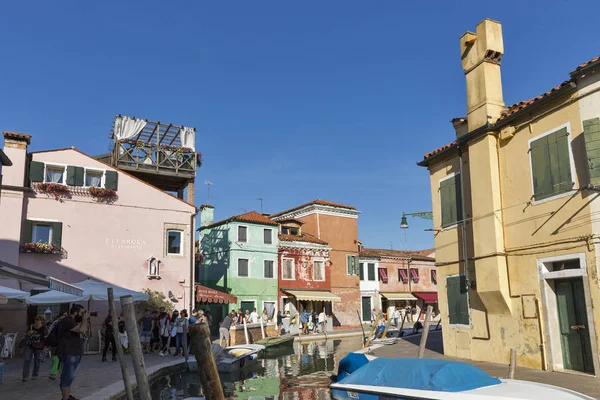 Tourist walk along the typical canal on Burano island, Italy. — Stock Photo, Image