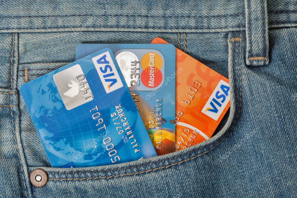KIEV, UKRAINE - AUGUST 09, 2016: MasterCard and Visa credit cards in front pocket of blue jeans closeup. Mastercard and Visa is an American multinational financial services corporations.