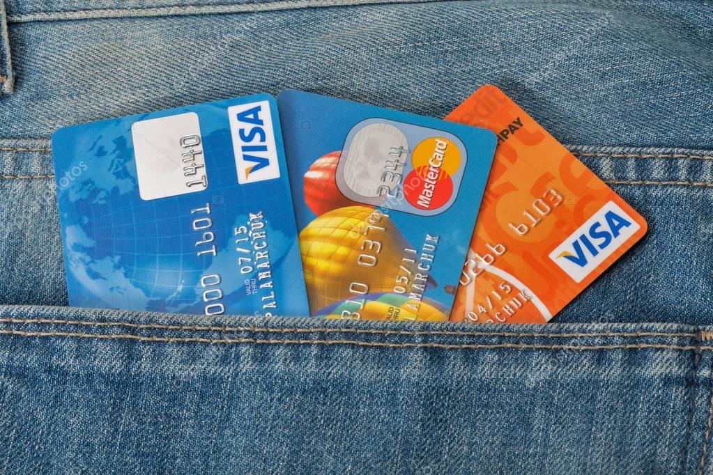 KIEV, UKRAINE - AUGUST 09, 2016: MasterCard and Visa credit cards in back pocket of blue jeans closeup. Mastercard and Visa is an American multinational financial services corporations.