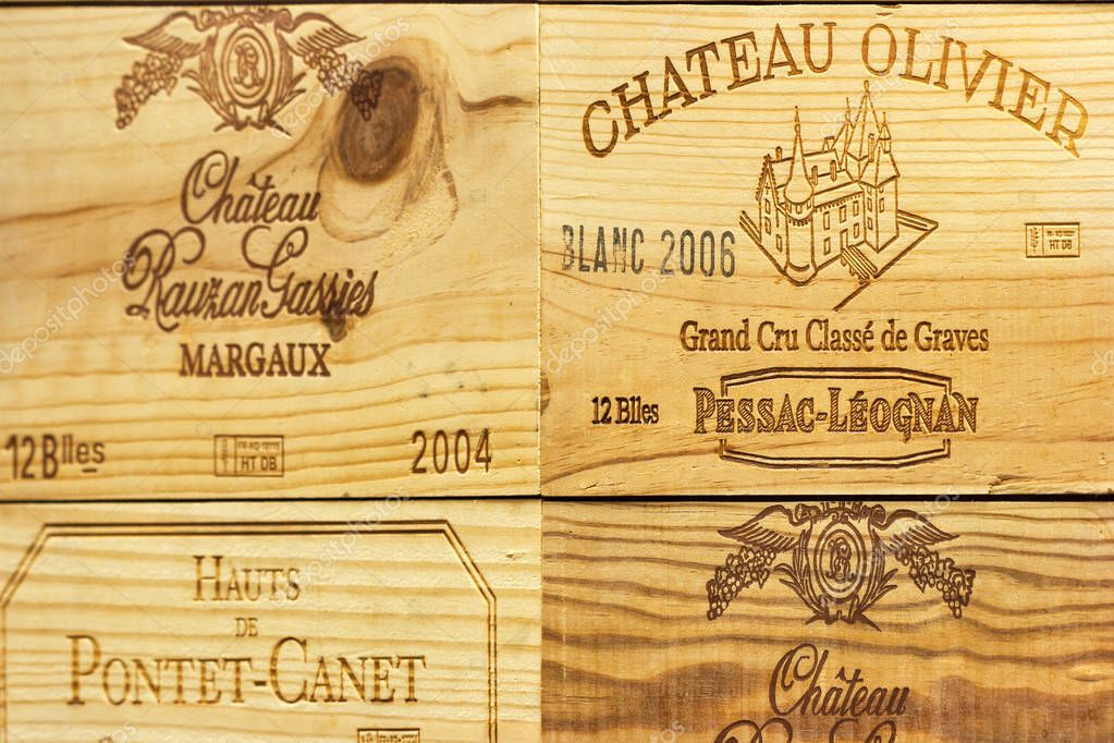 KIEV, UKRAINE - AUGUST 08, 2014: Corporate logo of the famous French winery Chateau Olivier and others on wooden wine boxes closeup. It is a Bordeaux wine from the Pessac-Leognan wine growing area.