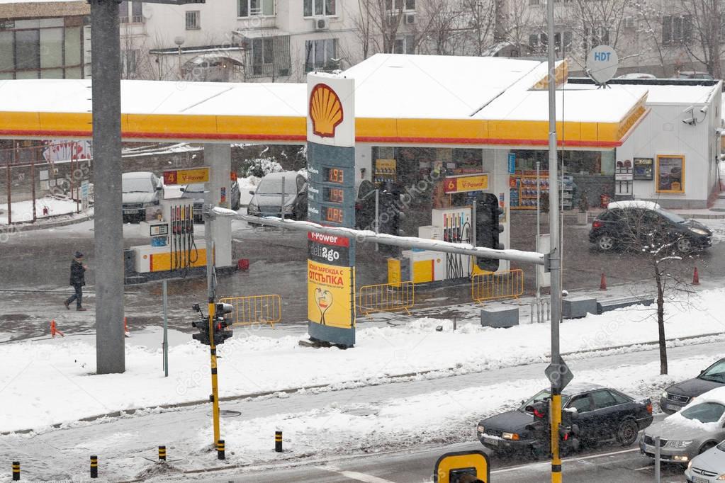 SOFIA, BULGARIA - JANUARY 09, 2015: Snowstorm on the city street with Shell gas station. Royal Dutch Shell plc, commonly known as Shell, is a Dutch multinational oil and gas company.