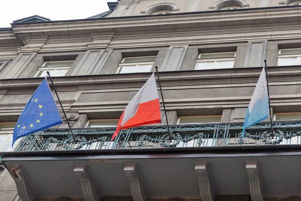 Drapeaux de l'UE, de la Pologne et de Cracovie sur le gros plan du bâtiment . — Photo