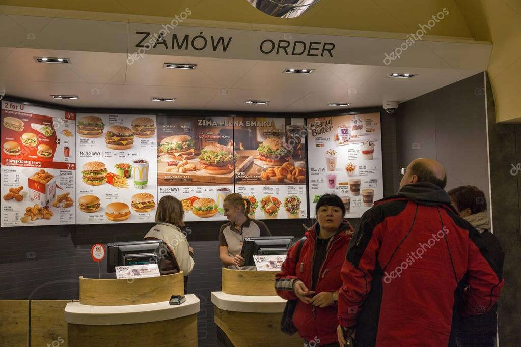 KRAKOW, POLAND - JANUARY 14, 2017: Unrecognized people visit McDonald's restaurant in Old Town. McDonald's is the world's largest chain of fast food restaurants.