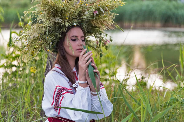 Beautiful girl in embroidery shirt and wreath of wild flowers. — Stock Photo, Image