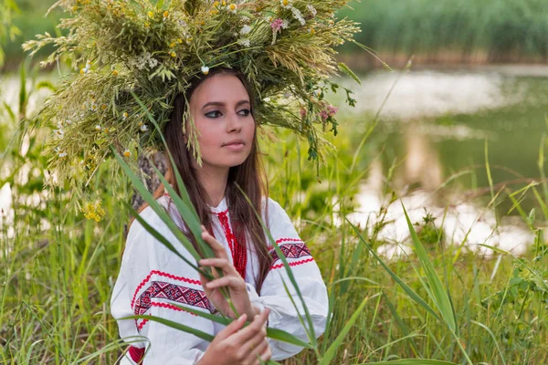 Beautiful girl in embroidery shirt and wreath of wild flowers. — Stock Photo, Image