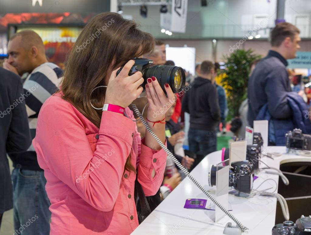 KIEV, UKRAINE - OCTOBER 07, 2017: Unrecognized visitors testing professional photographic cameras on Nikon booth during CEE 2017, the largest electronics trade show of Ukraine in KyivExpoPlaza EC.