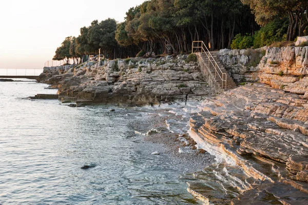 Zonsondergang rotsachtige strand in Istrië, Kroatië. — Stockfoto