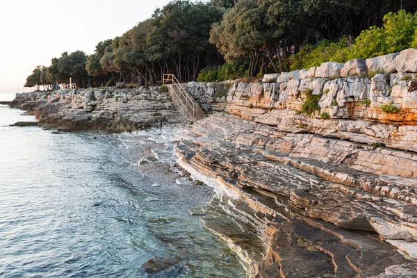 Zonsondergang rotsachtige strand in Istrië, Kroatië. — Stockfoto