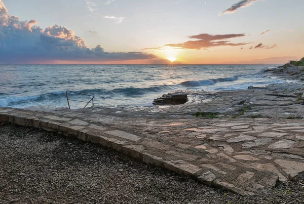 Rotsachtig strand zonsondergang op de kust van de Adriatische Zee, Kroatië — Stockfoto
