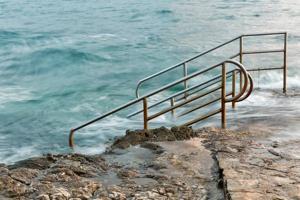Swim ladder leading to stormy mystic sea — Stock Photo, Image
