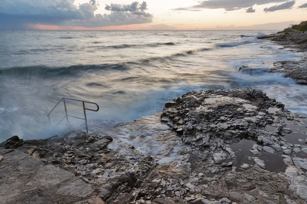 Tormentosa playa rocosa puesta de sol en la costa del mar Adriático —  Fotos de Stock