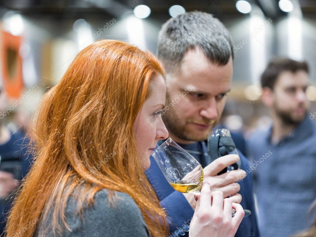 KIEV, UKRAINE - NOVEMBER 25, 2017: Unrecognized white young woman tasting Single Malt Scotch Whisky at 3rd Ukrainian Whisky Dram Festival in Parkovy Exhibition Center.