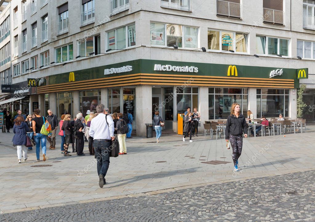 BRATISLAVA, SLOVAKIA - SEPTEMBER 25, 2017: People walk along McDonald's restaurant in Old Town. With a population of about 450 000, Bratislava is one of the smaller capitals of Europe.