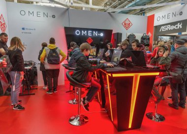 KYIV, UKRAINE - APRIL 13, 2019: Teens playing computers at game-centric Omen Hewlett-Packard brand of laptops and desktops at booth during CEE 2019, largest consumer electronics trade show of Ukraine