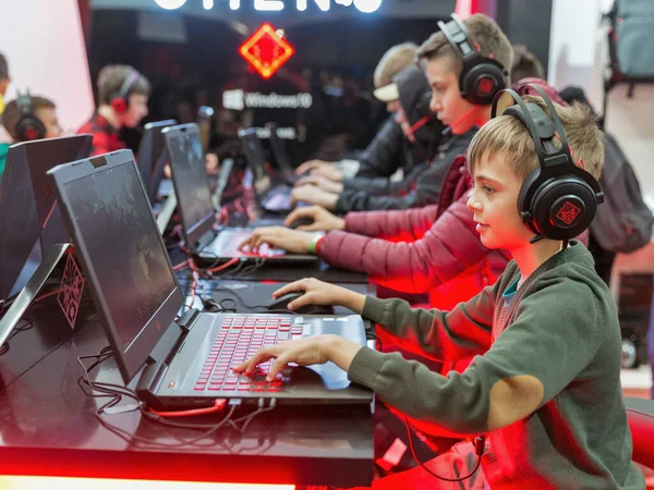 KYIV, UKRAINE - APRIL 13, 2019: Teens playing computers at game-centric Omen Hewlett-Packard brand of laptops and desktops at booth during CEE 2019, largest consumer electronics trade show of Ukraine