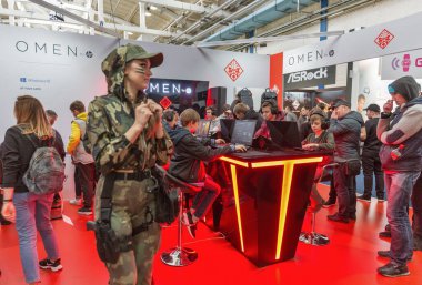 KYIV, UKRAINE - APRIL 13, 2019: Teens playing computers at game-centric Omen Hewlett-Packard brand of laptops and desktops at booth during CEE 2019, largest consumer electronics trade show of Ukraine