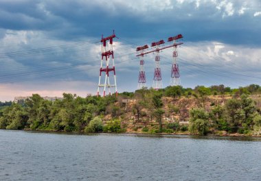 Ukrayna 'nın Khorytsia adasında günbatımında yüksek voltajlı elektrik hatları kuleleri.