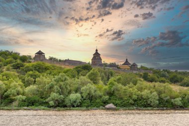 Ukrayna 'nın Khorytsia adasındaki Ortaçağ ahşap Zaporozhian Sich binaları. Gün batımında Dinyeper nehri.